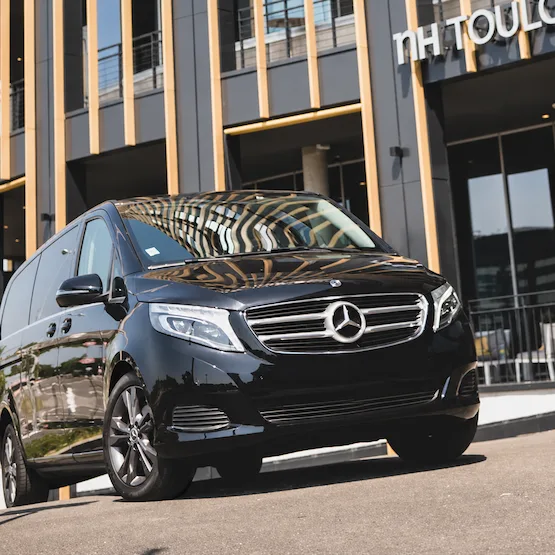 Van Mercedes noir stationné devant l’entrée de l’hôtel NH Toulouse.